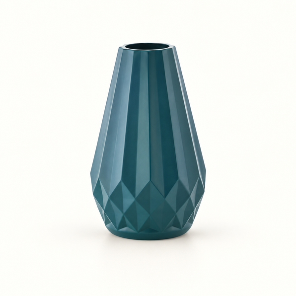 Vaso azul-petróleo com corpo alongado e relevos geométricos sobre fundo claro
